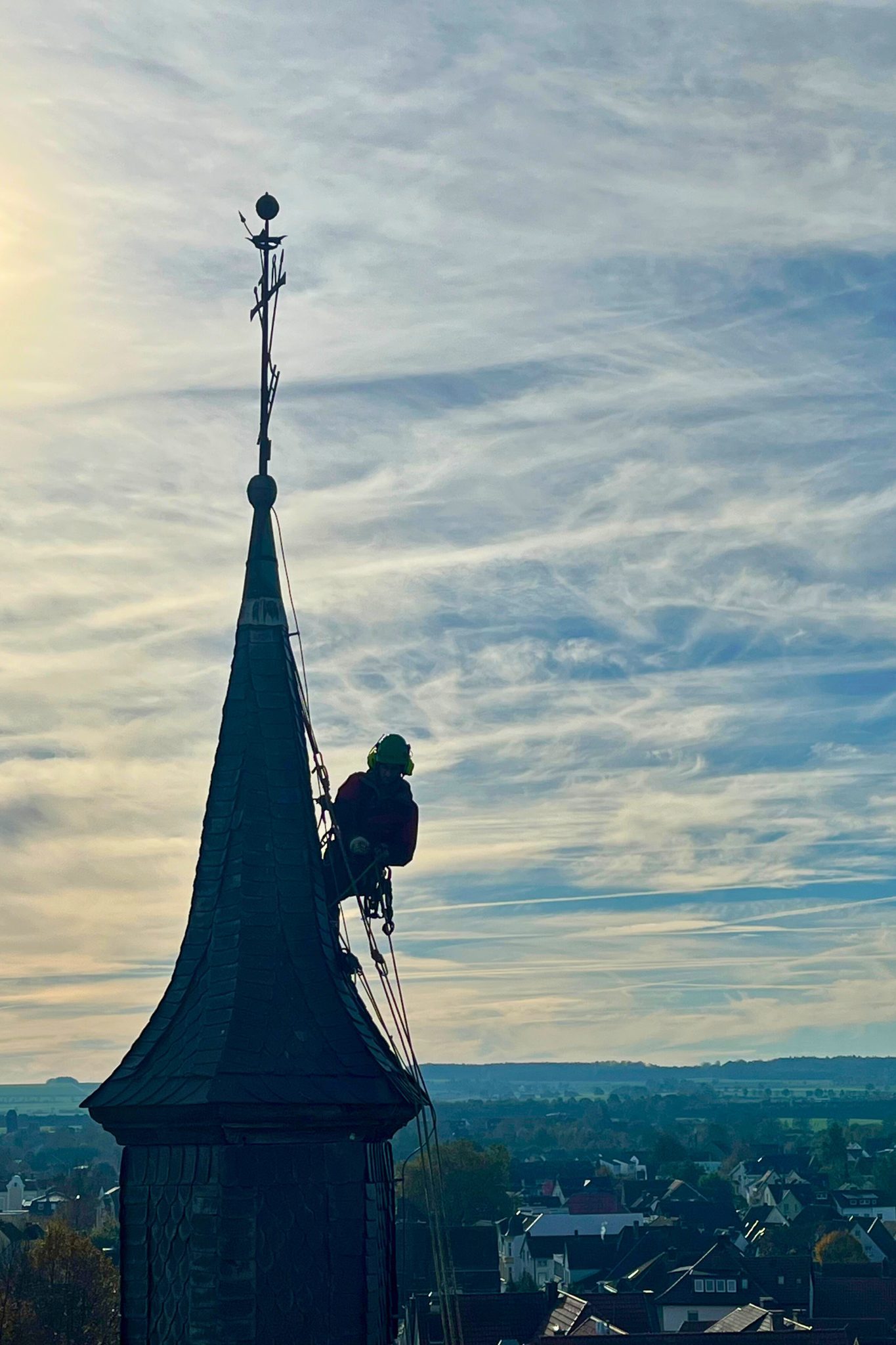 Dachdeckerarbeiten an einer Kirchturmspitze per Seilzugang