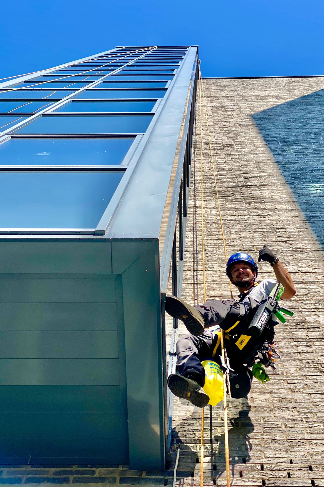 Industriekletterer bei der Glasreinigung eines modernen Bürogebäudes – sicher und effizient