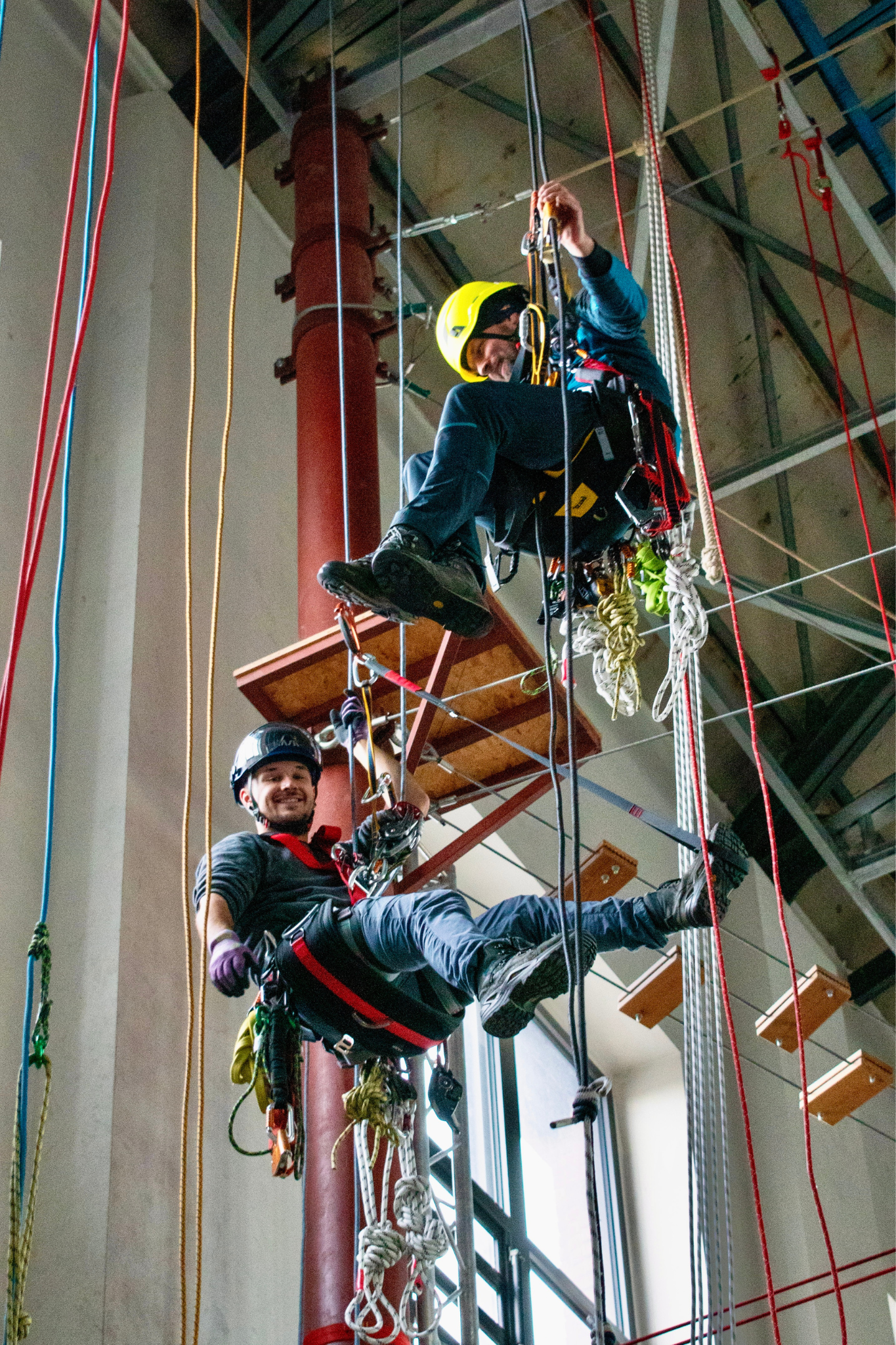 Zwei Industriekletterer bei einer Höhenrettungsübung mit vollständiger PSA und moderner Seiltechnik